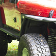 Load image into Gallery viewer, Fishbone Offroad Rock Slider W/Tube Step - Black Powdercoat fits Jeep LJ - Installation View