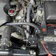Load image into Gallery viewer, J&amp;L 07-21 Toyota Tundra 5.7L Driver Side Oil Separator 3.0 - Black Anodized - Side View