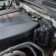 Load image into Gallery viewer, J&amp;L 16-23 Toyota Tacoma 3.5L Driver Side Oil Separator 3.0 - Black Anodized - Side View