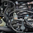 Load image into Gallery viewer, J&amp;L 16-24 Nissan Titan 5.6L Passenger Side Oil Separator 3.0 - Black Anodized - Detail View