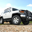 Load image into Gallery viewer, Rough Country 3 Inch Lift Kit | Red Spacers | Toyota 4Runner (03-09)/FJ Cruiser (07-14) 76530RED - Installation View